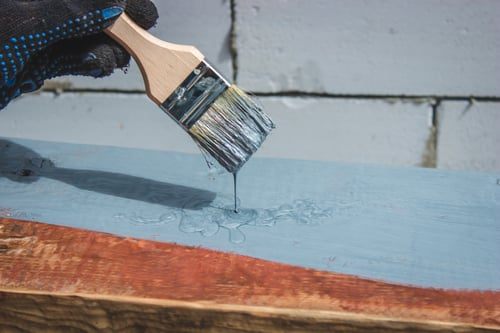 Brush applying a protective waterproof coating to a prepared surface