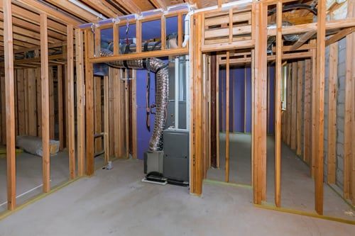 Framed basement interior prepared for waterproofing and finishing work