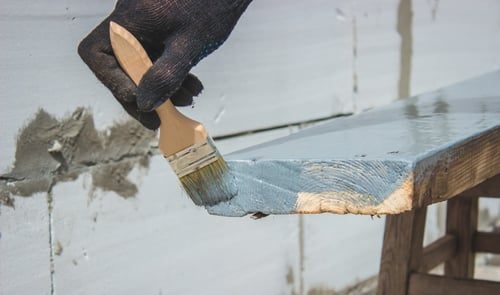 Technician brushing a waterproof coating onto a concrete surface